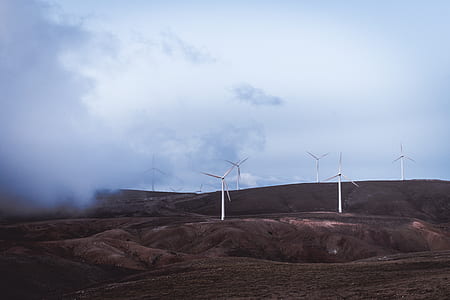 white wind turbines on hill during daytime thumbnail