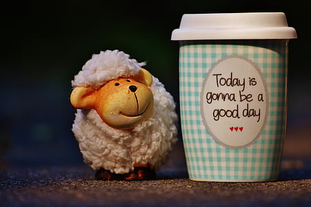 shallow focus photography of ceramic sheep figurine beside blue vase thumbnail