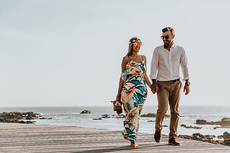 man and woman holding hands while walking thumbnail