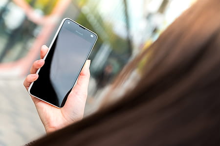 Woman uses her modern smartphone on the street. thumbnail