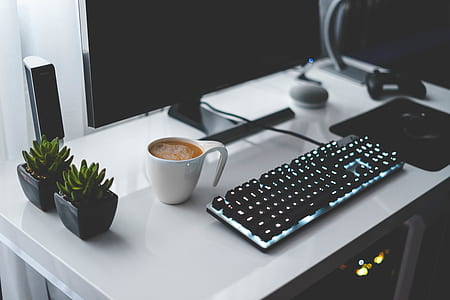 black keyboard near white ceramic mug with turned off monitor thumbnail