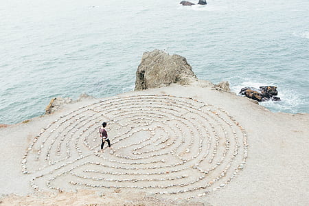 person standing on drawn sand beside sea thumbnail