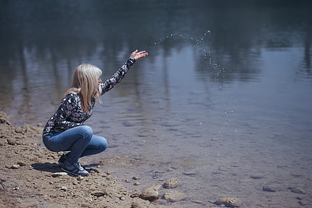 woman kneel near beside body of water during daytime thumbnail