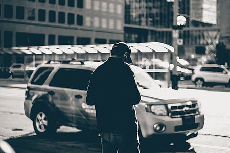 man standing near white Ford Escape SUV thumbnail