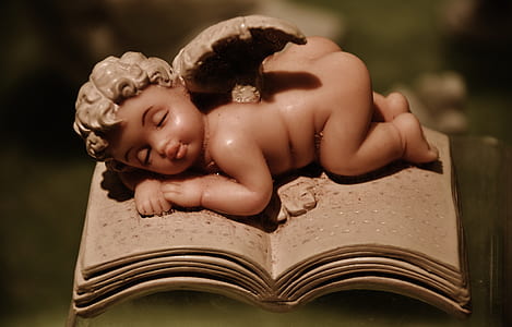 sleeping baby on book figurine thumbnail