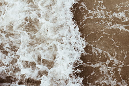 aerial photography of waves hitting sand thumbnail