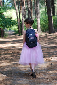 girl wearing backpack walking on pathway thumbnail