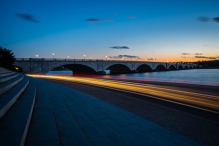 time-lapse photo of car near body of water and bridge thumbnail