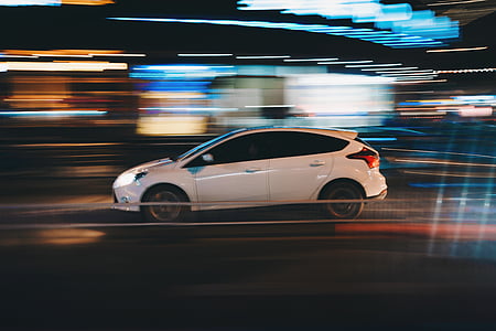 time-lapse photography of white Ford Focus 5-door hatchback with lights background on road thumbnail