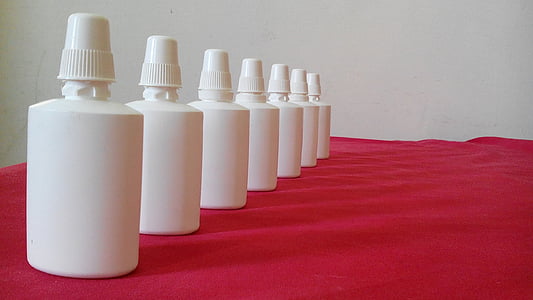 several white plastic bottles on red cloth thumbnail
