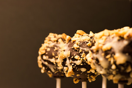 close-up photography of three chocolate lollipops with peanuts thumbnail