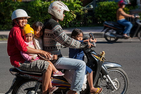 family riding a motorcycle on roadway thumbnail