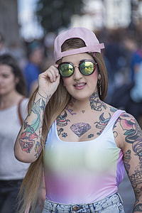 woman holding sunglasses while walking outdoor during daytime thumbnail