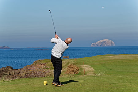 man playing golf on field thumbnail
