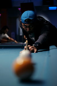man holding cue stick pointing billiard ball thumbnail