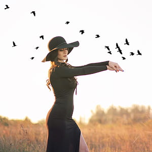 woman wearing black bodycon dress standing near field with arms forward thumbnail