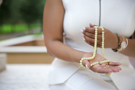 woman holding white misbaha prayer beads thumbnail