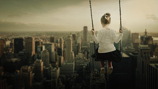 girl sitting on swing with overlooking skycrapers thumbnail