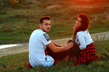 man and woman sitting on green grass during daytime thumbnail