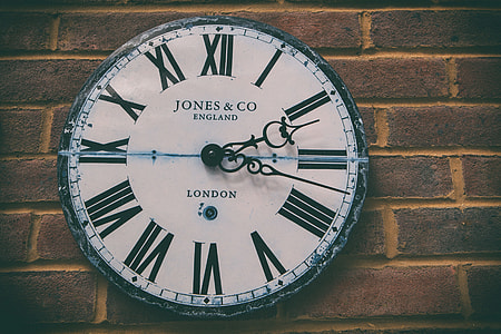Image of a faded retro-style clock against a brick wall background thumbnail