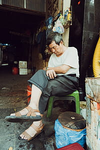 Man Wearing White Shirt and Gray Dress Pants Sitting on Green Stool thumbnail