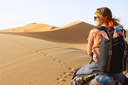 woman traveling on desert during daytime thumbnail