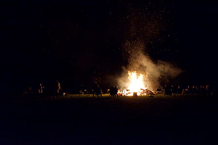 group of people standing near bonfire thumbnail