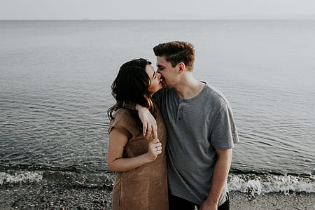 man and woman about to kiss beside seashore during daytime thumbnail