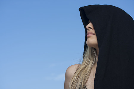 woman wearing black hoodie looking above blue sky thumbnail