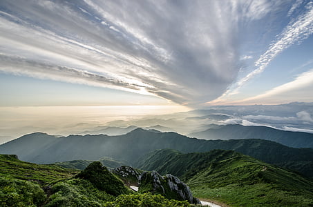 bird's eye view of green valley under cloudy sky thumbnail