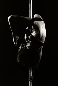 grayscale photograph of woman dancing on pole thumbnail