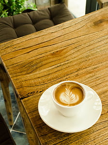 white ceramic teacup with lathe on brown wooden table thumbnail