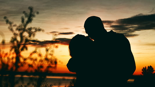 silhouette of man and woman kissing during sunset thumbnail