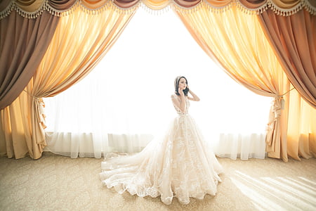 woman wear white wedding dress near curtain thumbnail