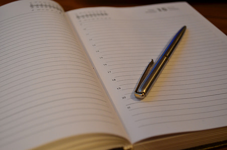gray stainless steel click pen on white notebook thumbnail