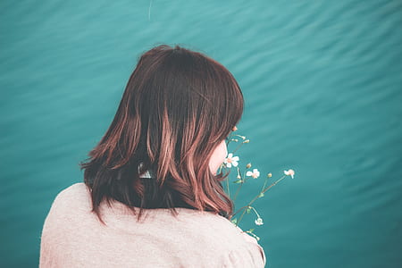 woman sniffing white petaled flowers thumbnail