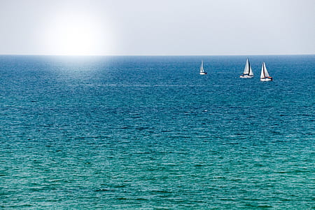 three sail boats on body of water thumbnail