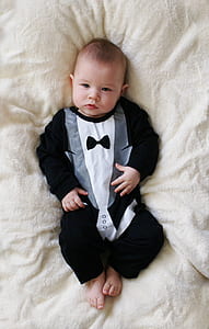 person showing baby's tuxedo-themed footie thumbnail