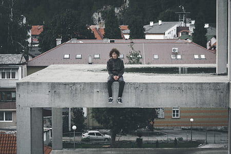 man sitting on concrete building thumbnail