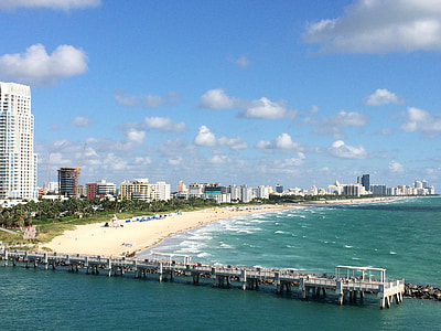 aerial photo of people standing on shore near ocean during daytime thumbnail