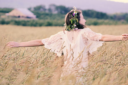 Woman in White Mesh Dress Surrounded by Brown Plants thumbnail