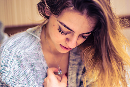 woman looking down her pendant necklace thumbnail