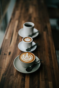tilt shift lens photography of white ceramic coffee cups and saucers thumbnail