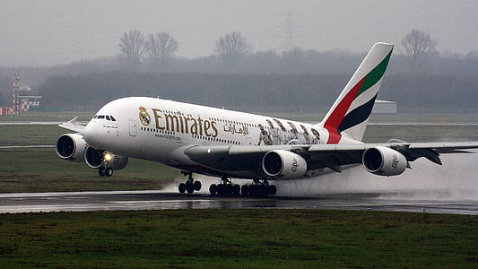 white Emirate airplane passing on runway at daytime thumbnail