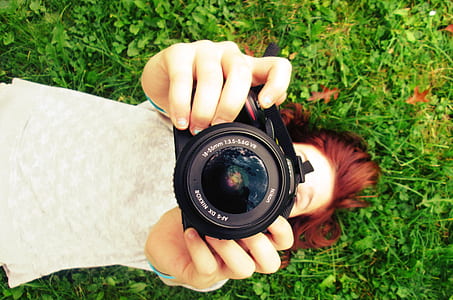 woman holding black DSLR camera during daytime thumbnail