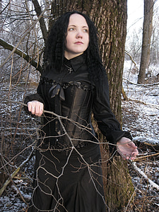 woman in black Victorian era dress near brown tree thumbnail