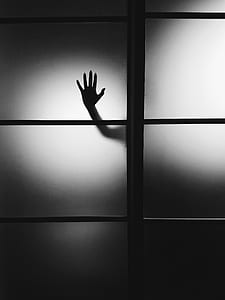 silhouette of person's right hand on glass door thumbnail