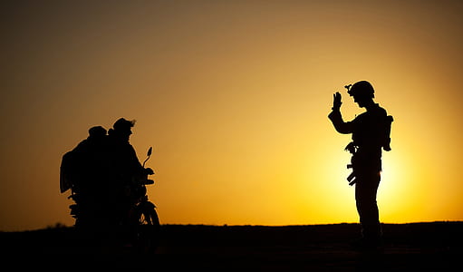 soldier greeting motorcycle rider at golden hour thumbnail