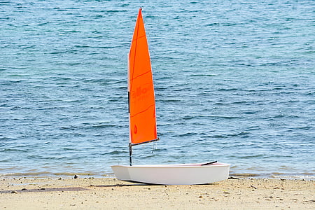 white and orange sailing boat on the seashore thumbnail