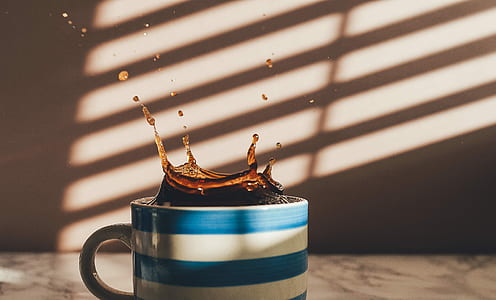 blue and white striped ceramic mug filled with liquid thumbnail